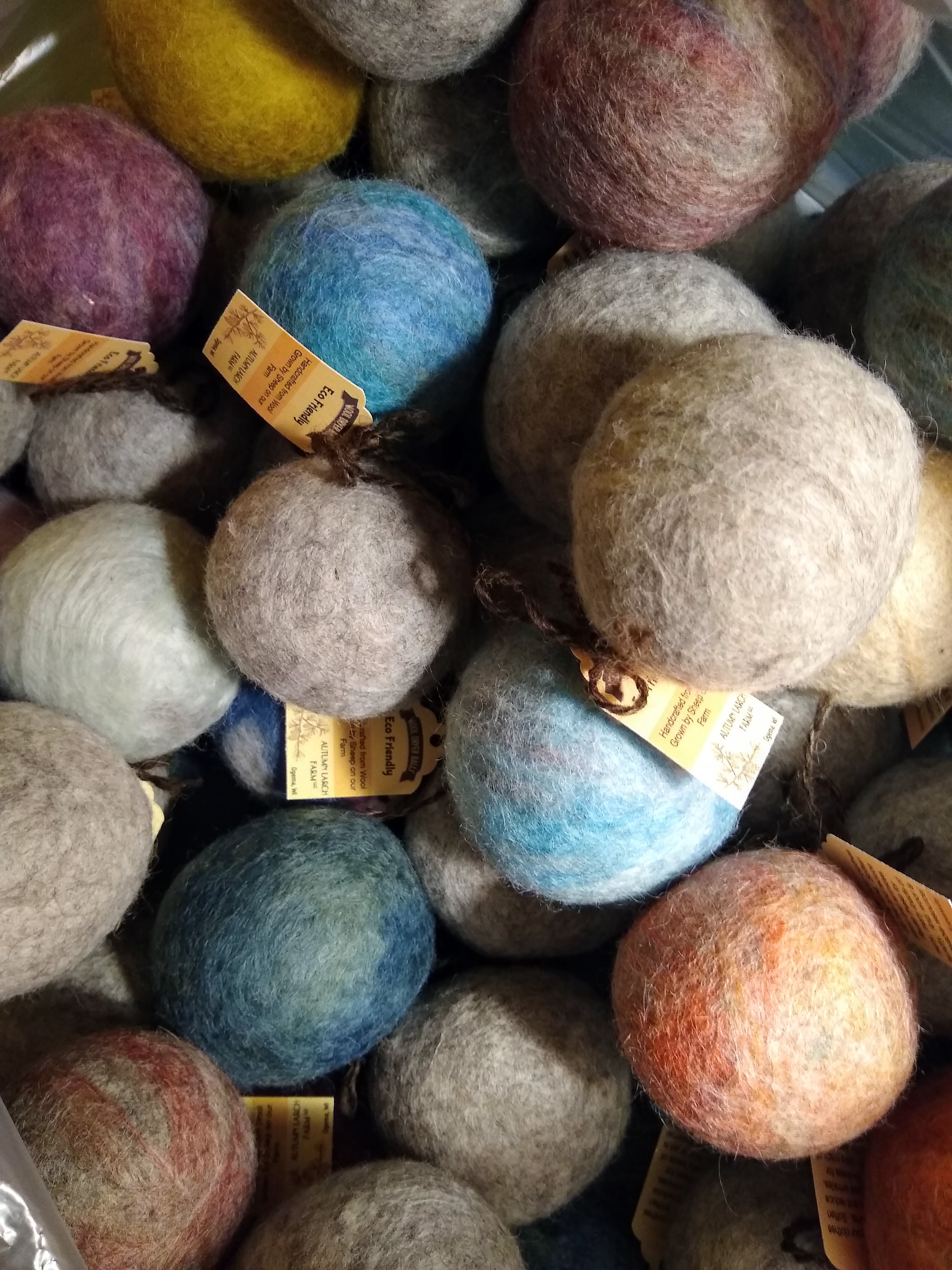 Many wool dryer balls of varying colors all mounded together.